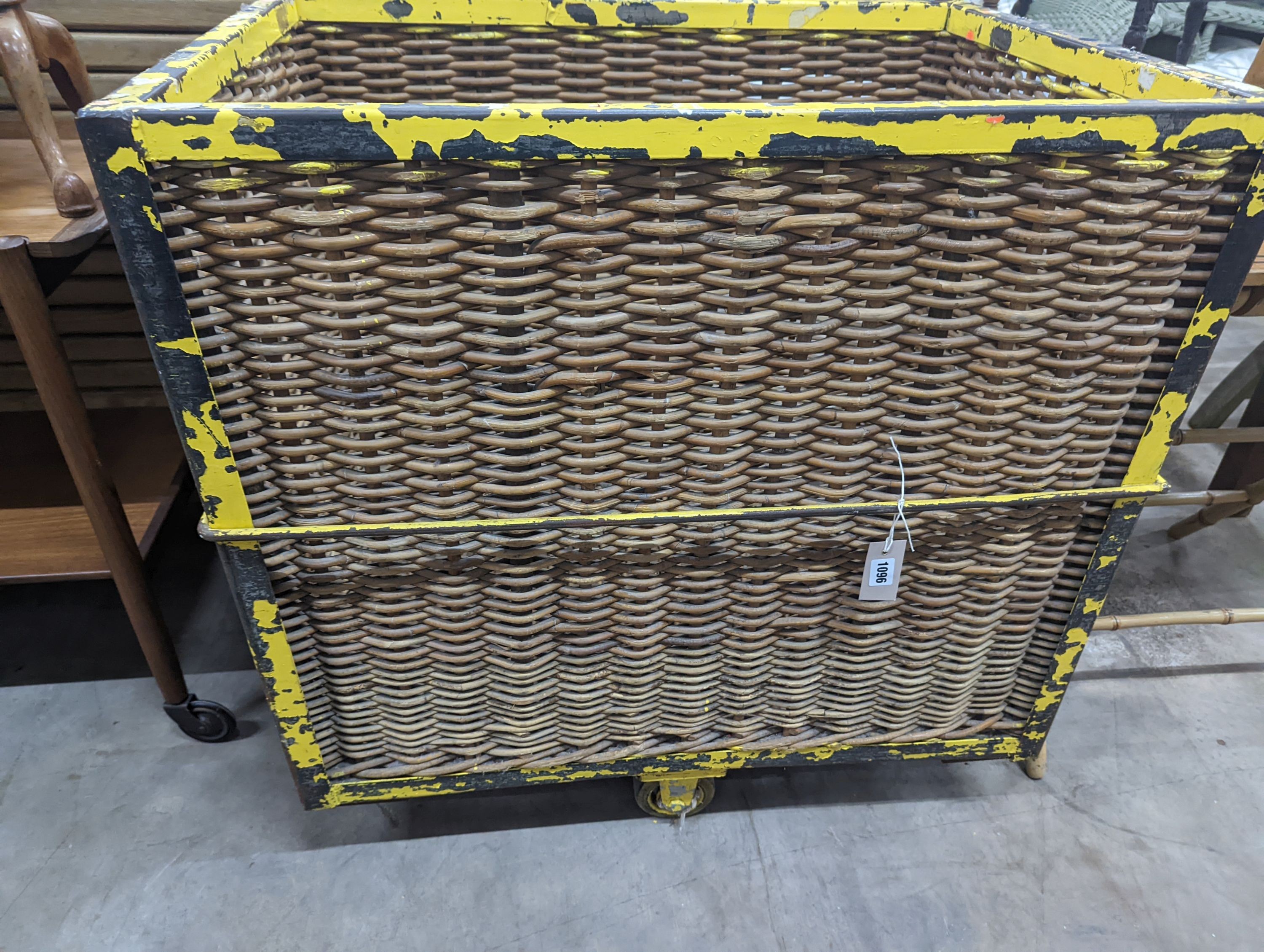 A vintage wicker and iron laundry basket on wheels, width 85cm, depth 61cm, height 87cm